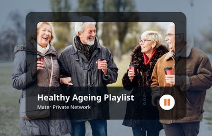 Two couples are walking through a park and each have a coffee cup in their hands. They are laughing and looking at each other. They are wearing in warm clothing.