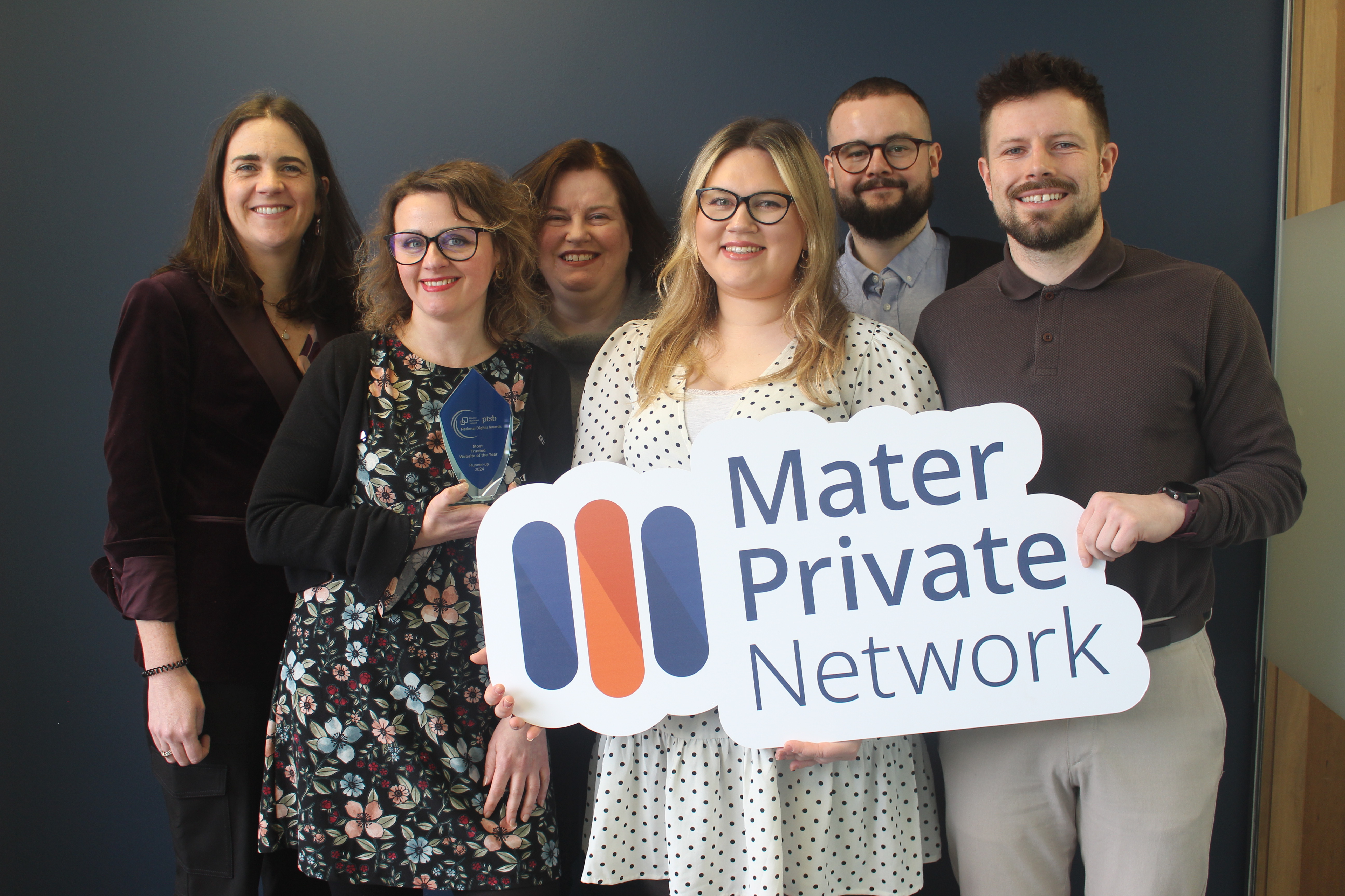 The Mater Private Network marketing team, consisting of four women and two men are smiling with an award plaque and a Mater Private Network sign.