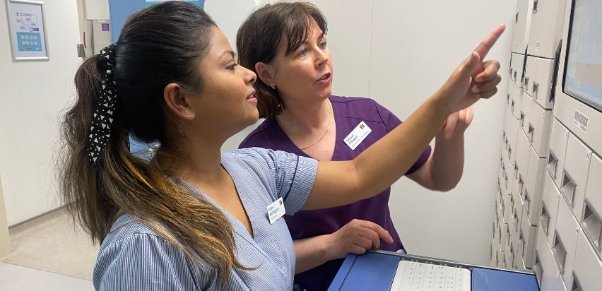 Two Mater Private Network health professionals are pointing at the new medication dispensing equipment.