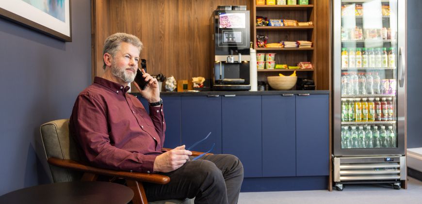 Patient sitting on the patient lounge talking on the phone