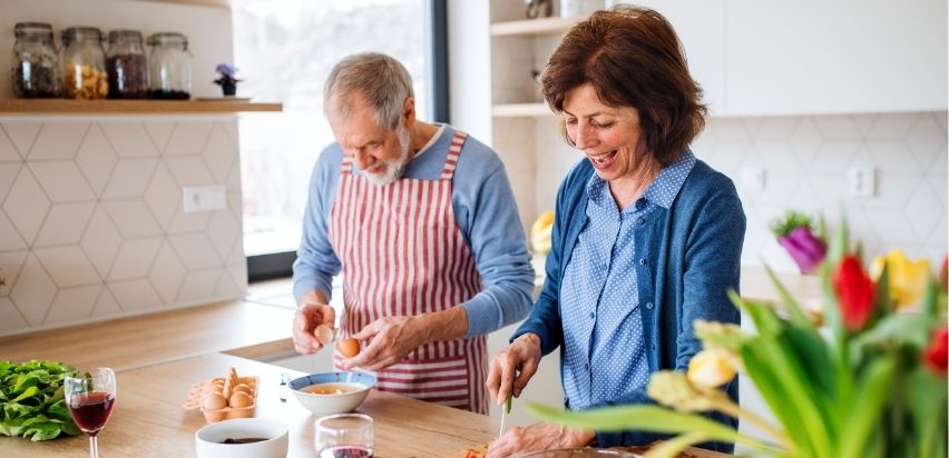 A married couple cooking together.