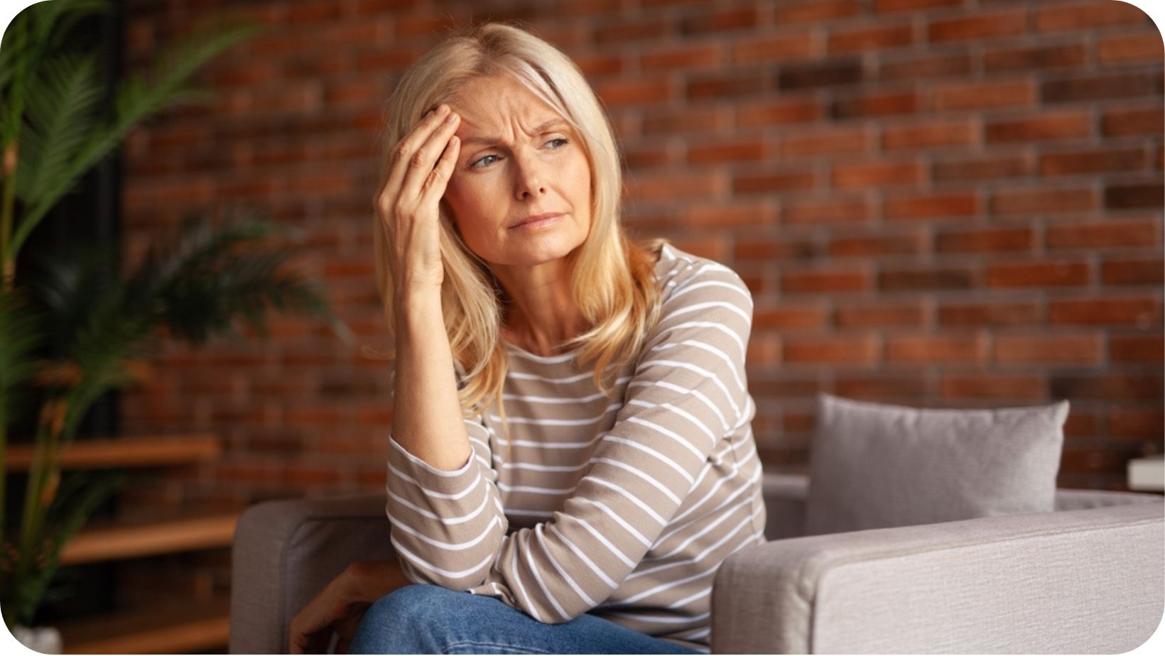 Thoughtful middle age woman sitting on the sofa