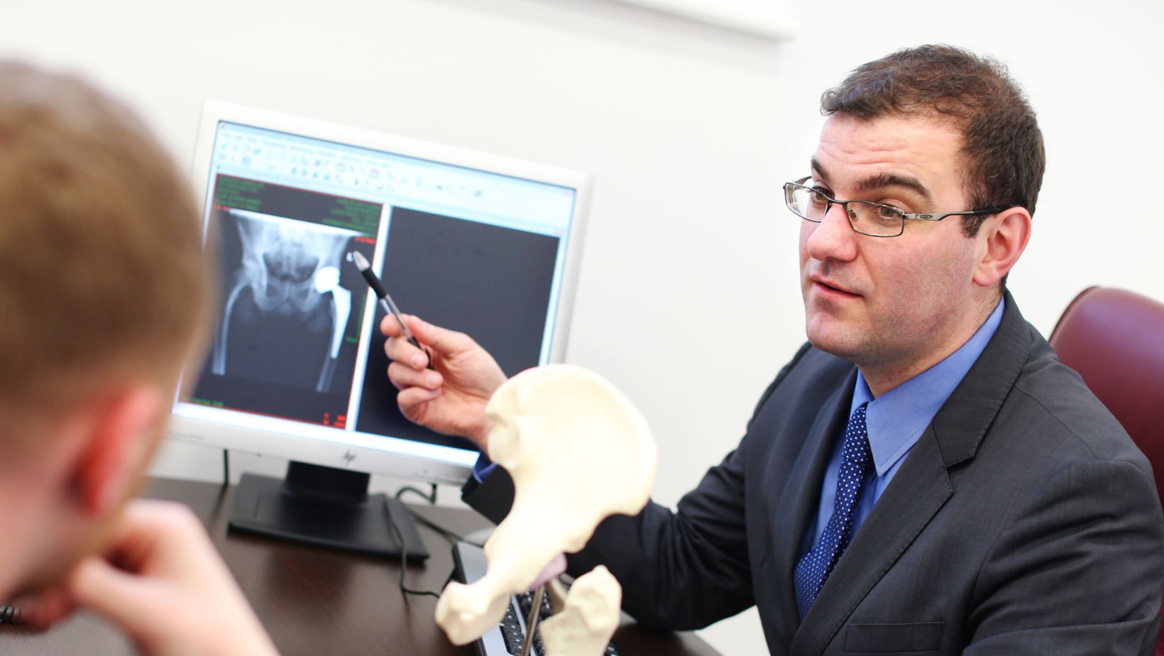 Orthopeadic Surgeon Mr. Cashman talking with a patient in a clinic room