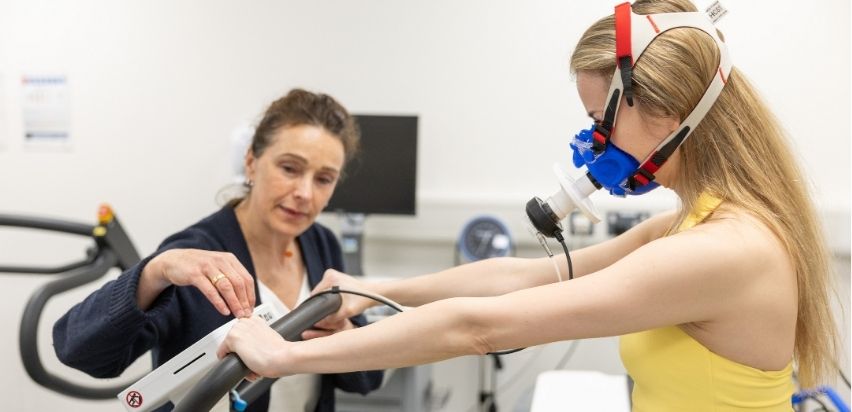 Female patient performing a VO2 max test on a bike