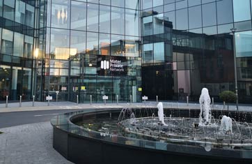The main entrance to Mater Private Network in Cork, featuring the front door and a water fountain outside the door.