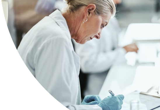 A female medical professional in a lab writing something down.