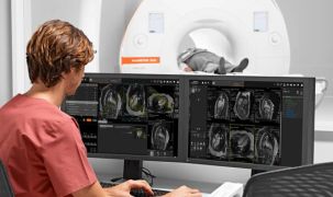 A radiologist examines MRI scans on a computer while a patient is inside the MRI machine.