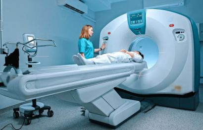 A patient undergoing a nuclear medicine scan, with a medical professional standing beside the machine.