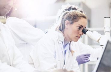 Researcher using a microscope in a laboratory setting