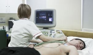 Nurse conducting an echocardiography on a young male patient